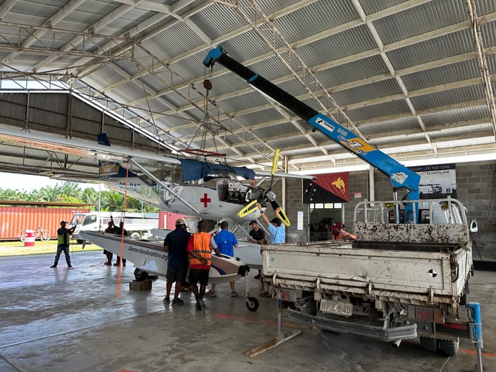 Samaritan Aviation attaching floats to a Cessna amphibious missionary float plane in Papua New Guinea